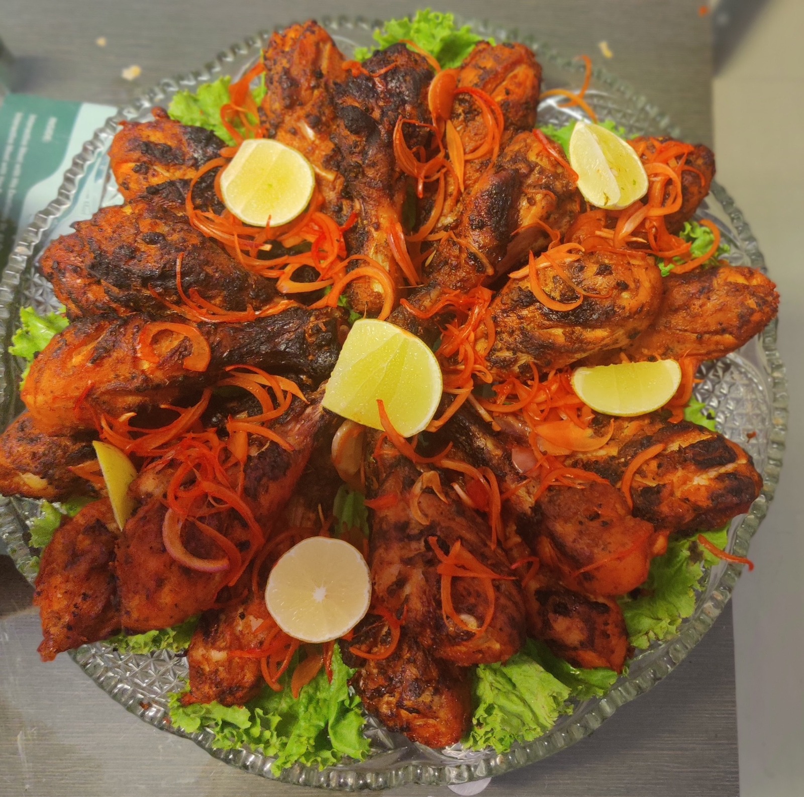 Tandoori chicken platter with lemon and carrot garnish